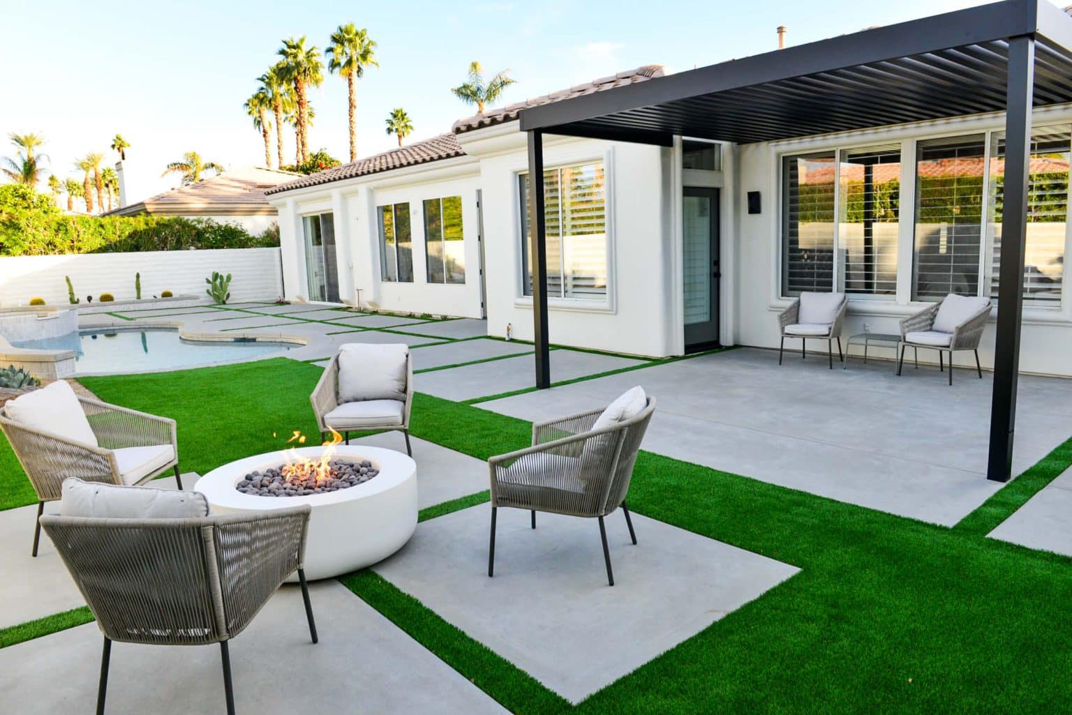 Backyard landscape transformation in Rancho Mirage including hardscape, fire feature, breeze block, masonry, low voltage lighting, artificial turf, irrigation and desert plants.