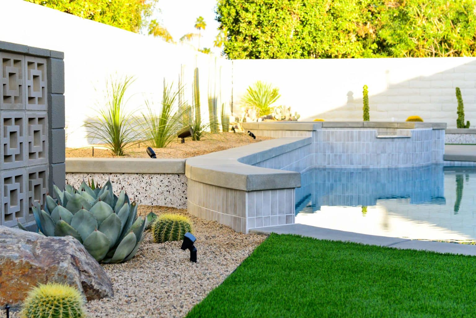 Backyard landscape transformation in Rancho Mirage including hardscape, fire feature, breeze block, masonry, low voltage lighting, artificial turf, irrigation and desert plants.