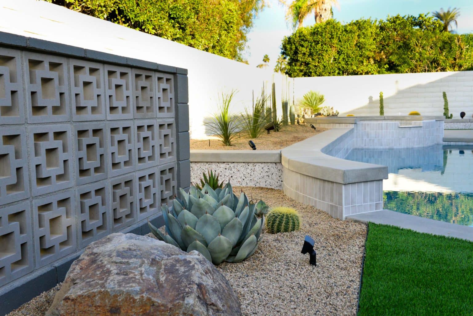 Backyard landscape transformation in Rancho Mirage including hardscape, fire feature, breeze block, masonry, low voltage lighting, artificial turf, irrigation and desert plants.