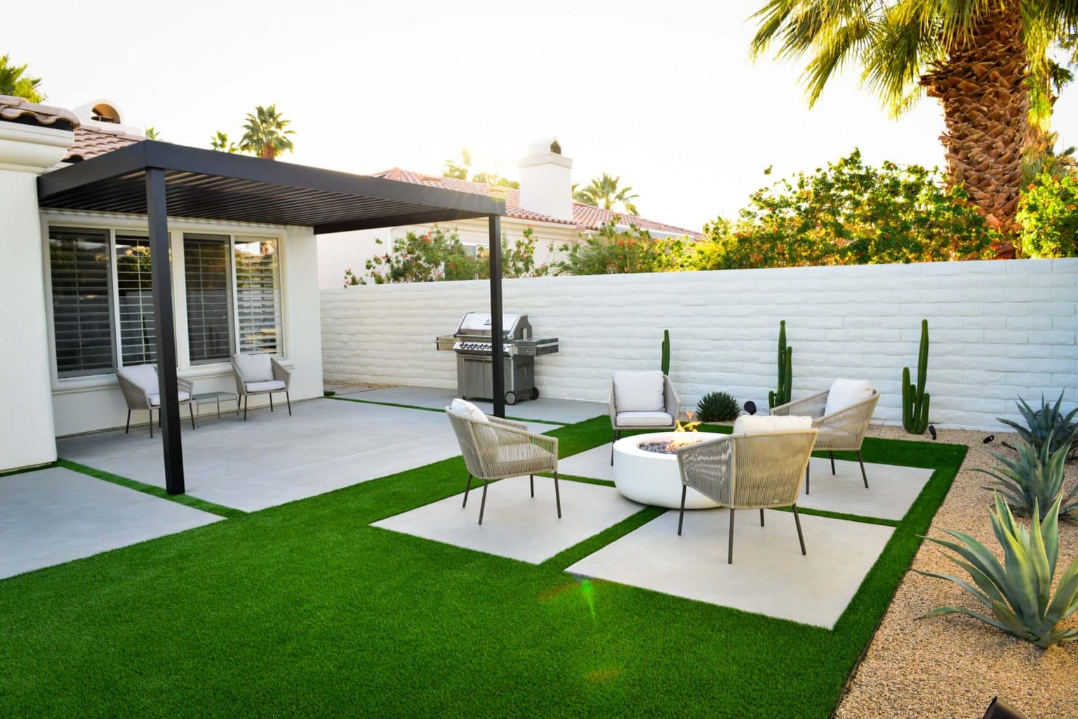 Backyard landscape transformation in Rancho Mirage including hardscape, masonry, breeze block, fire feature, low voltage lighting, artificial turf, and desert plants.
