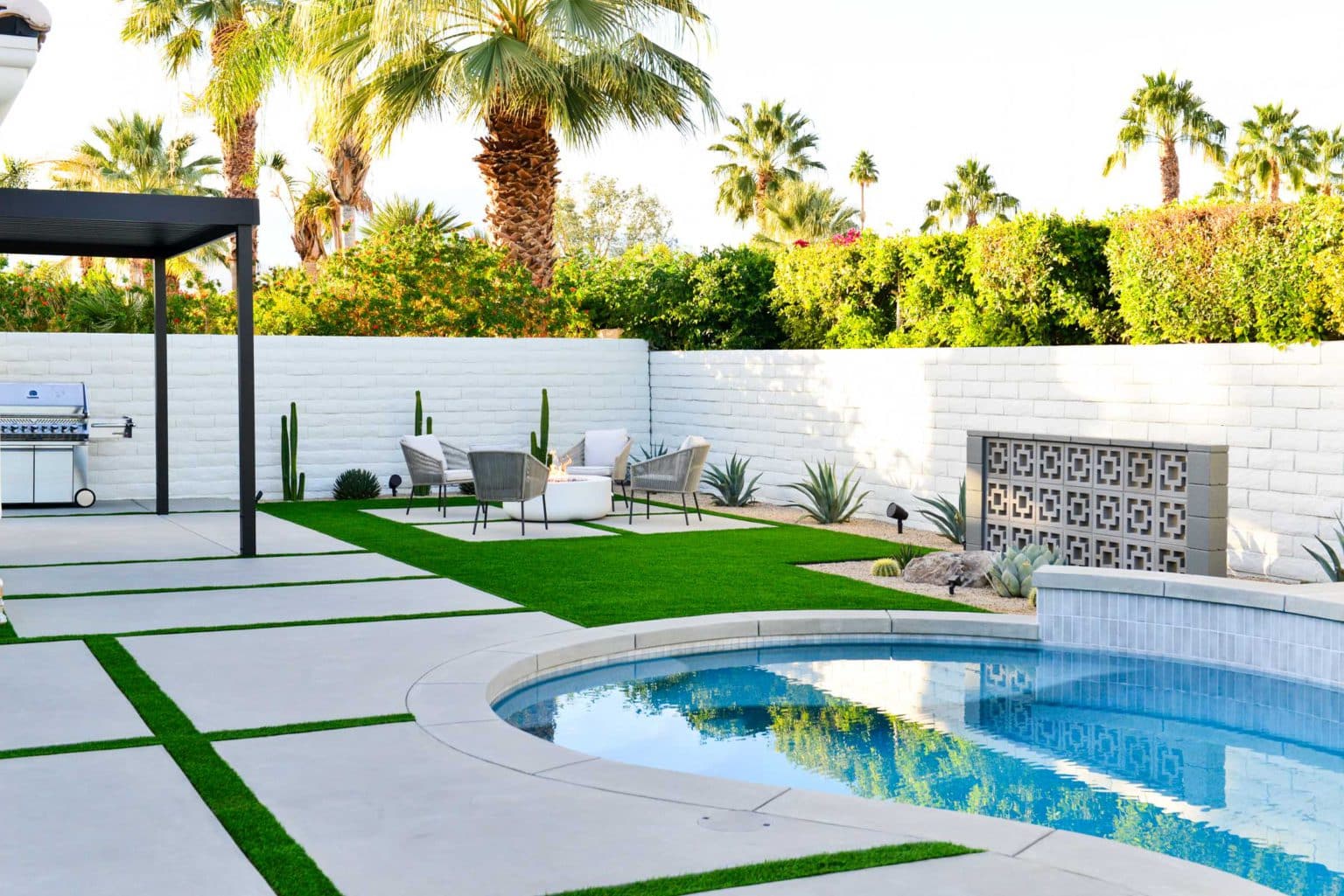 Backyard landscape transformation in Rancho Mirage including hardscape, fire feature, breeze block, masonry, low voltage lighting, artificial turf, irrigation and desert plants.