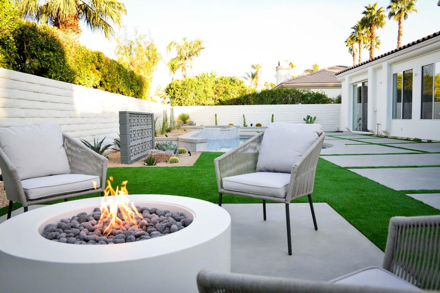 Backyard landscape transformation in Rancho Mirage including hardscape, fire feature, breeze block, masonry, low voltage lighting, artificial turf, irrigation and desert plants.