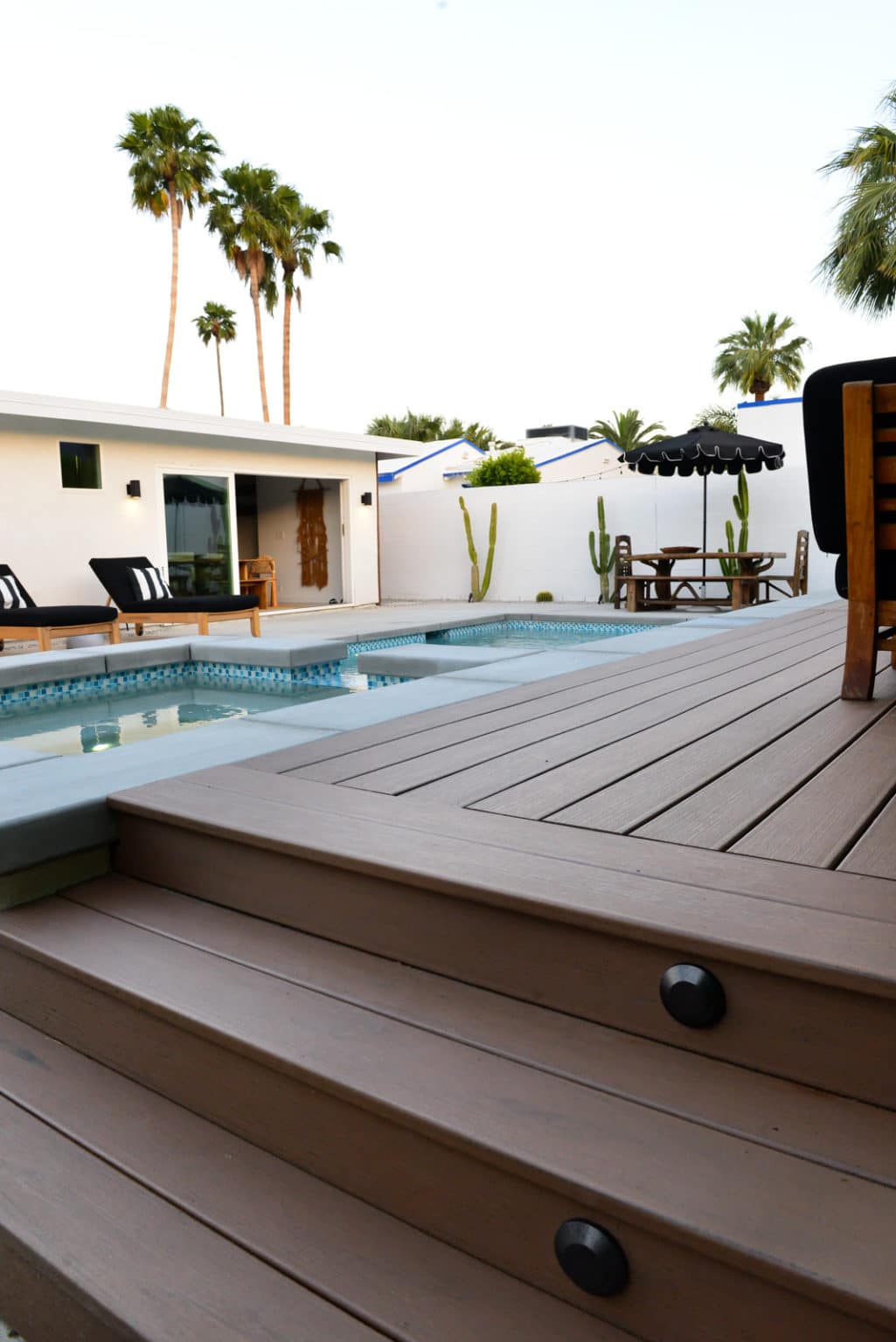 Backyard landscape transformation in Palm Springs including multi-level composite decking, hardscape, fire feature, breeze block, masonry, low voltage lighting, artificial turf, irrigation and desert plants.