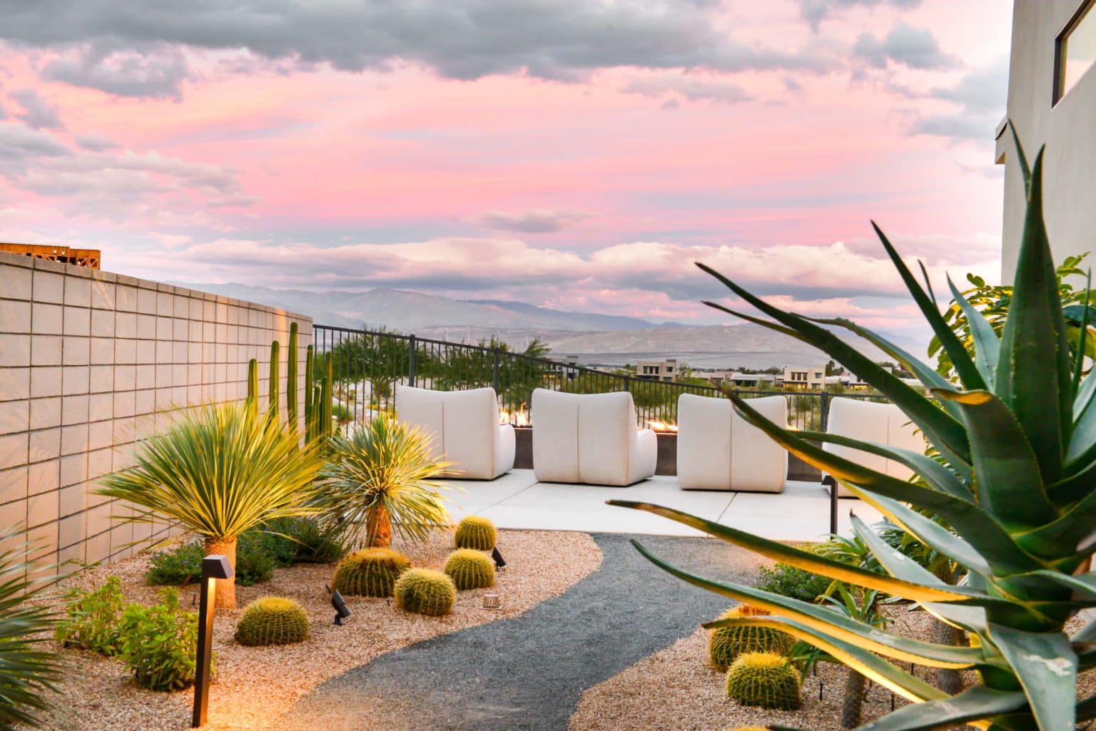 Residential landscape design and installation in Palm Springs, including desert plants, low voltage lighting, boulders, irrigation, and decorative metal panels.