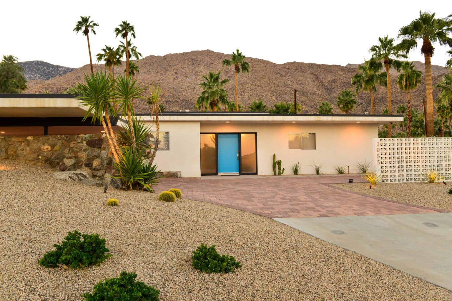 Complete residential landscape design and installation in Palm Springs, including hardscape, custom outdoor shower with tile, fire feature, low voltage lighting, boulders, artificial turf, irrigation and desert plants.
