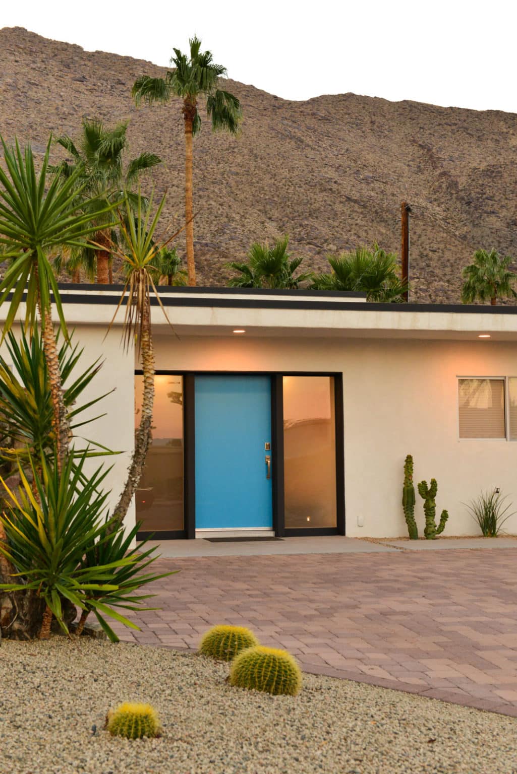 Complete residential landscape design and installation in Palm Springs, including hardscape, custom outdoor shower with tile, fire feature, low voltage lighting, boulders, artificial turf, irrigation and desert plants.