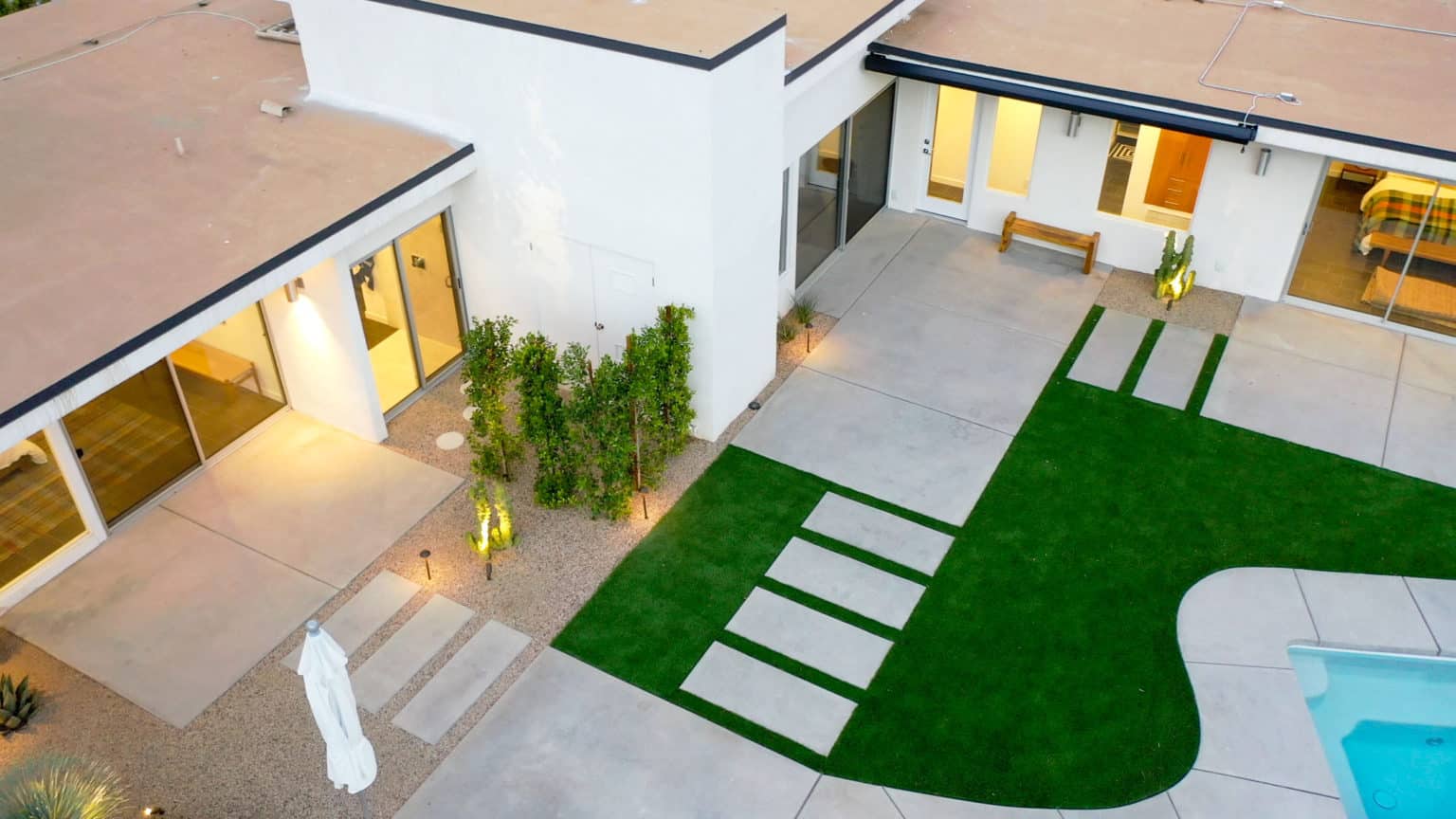 Complete residential landscape design and installation in Palm Springs, including hardscape, custom outdoor shower with tile, fire feature, low voltage lighting, boulders, artificial turf, irrigation and desert plants.