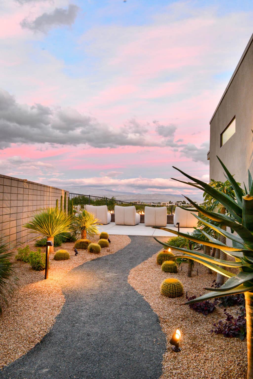 Residential landscape design and installation in Palm Springs, including desert plants, low voltage lighting, boulders, irrigation, and decorative metal panels.