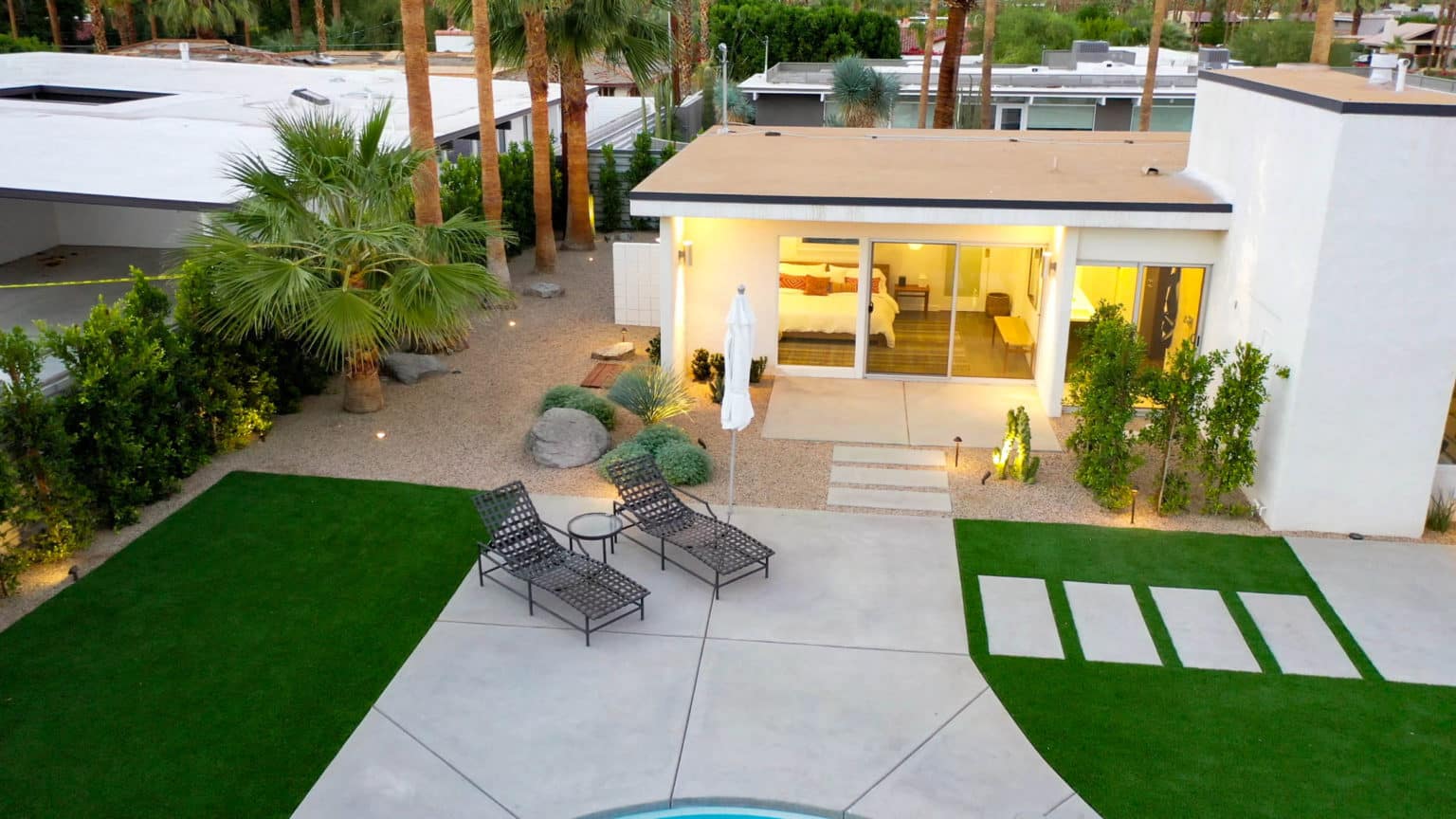 Complete residential landscape design and installation in Palm Springs, including hardscape, custom outdoor shower with tile, fire feature, low voltage lighting, boulders, artificial turf, irrigation and desert plants.