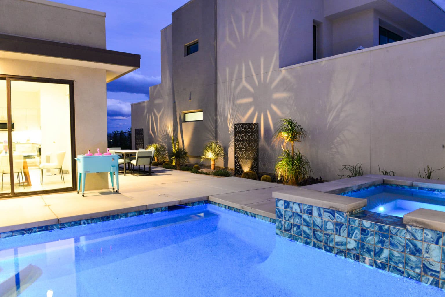 Residential landscape design and installation in Palm Springs, including desert plants, low voltage lighting, boulders, irrigation, and decorative metal panels.