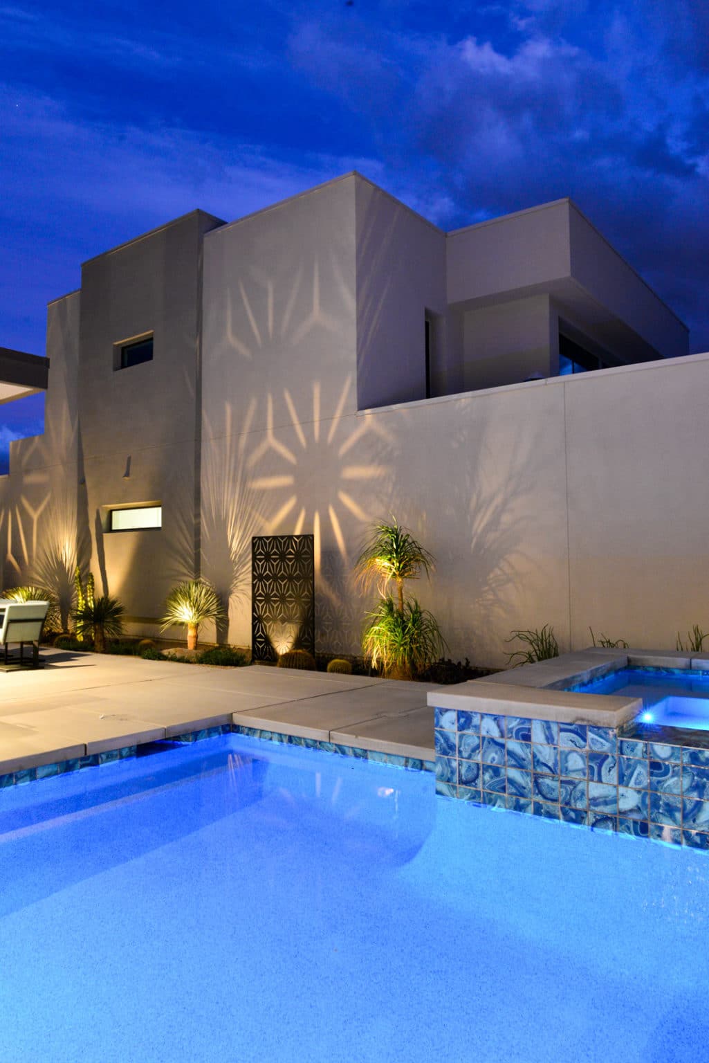 Residential landscape design and installation in Palm Springs, including desert plants, low voltage lighting, boulders, irrigation, and decorative metal panels.