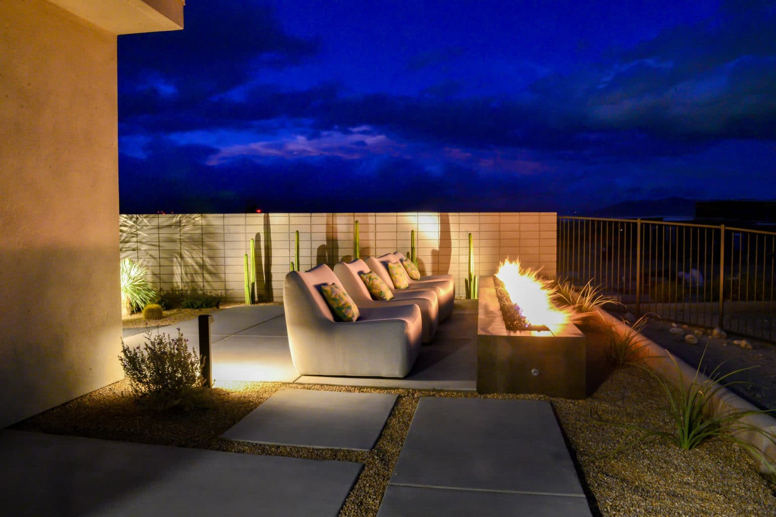 Residential landscape design and installation in Palm Springs, including desert plants, low voltage lighting, boulders, irrigation, and decorative metal panels.