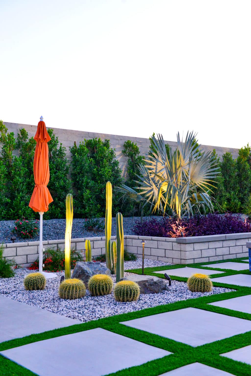 Backyard landscape transformation in Rancho Mirage, including hardscape, outdoor kitchen with pizza oven, low voltage lighting, Boulders, decomposed granite, artificial turf, irrigation and desert plants.