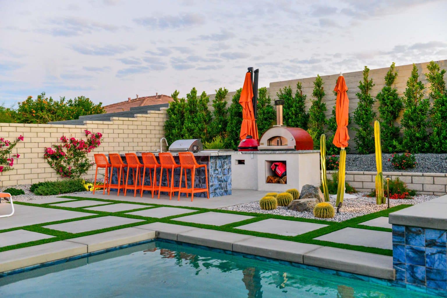 Backyard landscape transformation in Rancho Mirage, including hardscape, outdoor kitchen with pizza oven, low voltage lighting, Boulders, decomposed granite, artificial turf, irrigation and desert plants.
