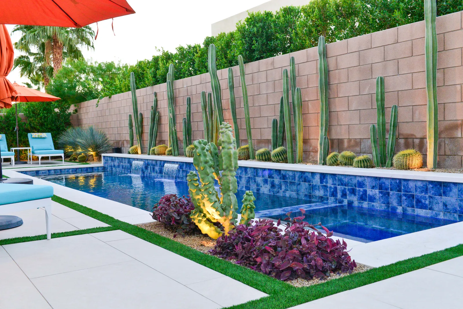 Raised bond beam with mitered stone coping and twin spillways into the pool