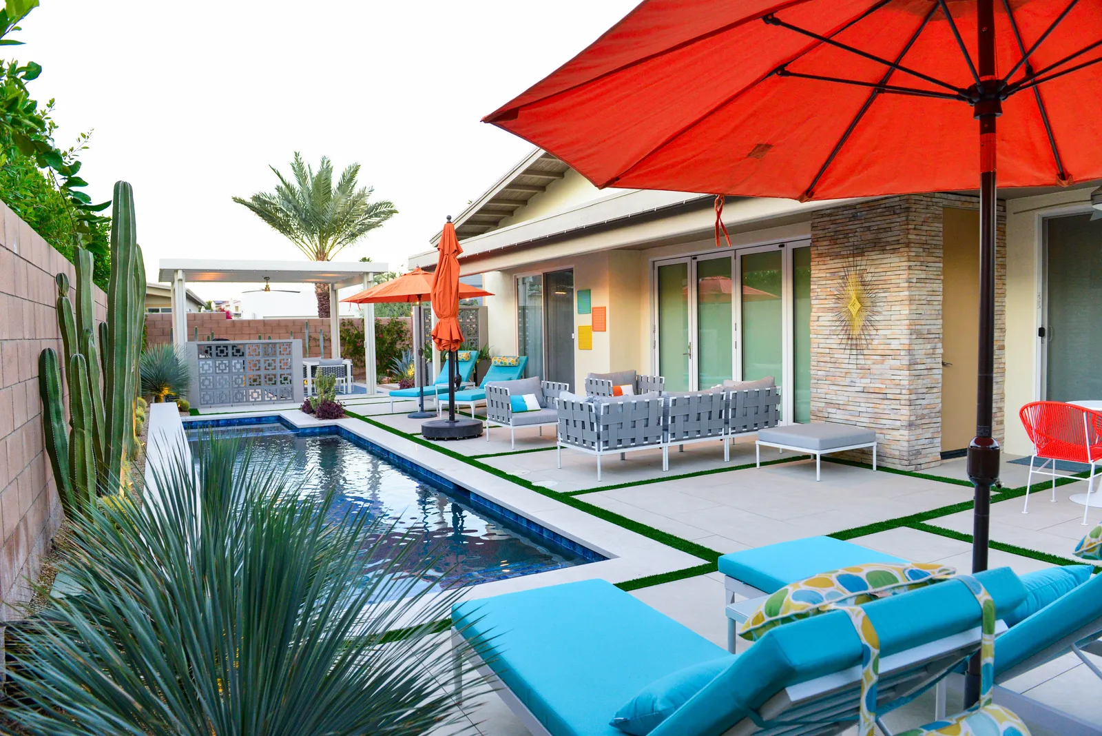 Pool deck with paver and turf grid and desert planting along a mid-century house