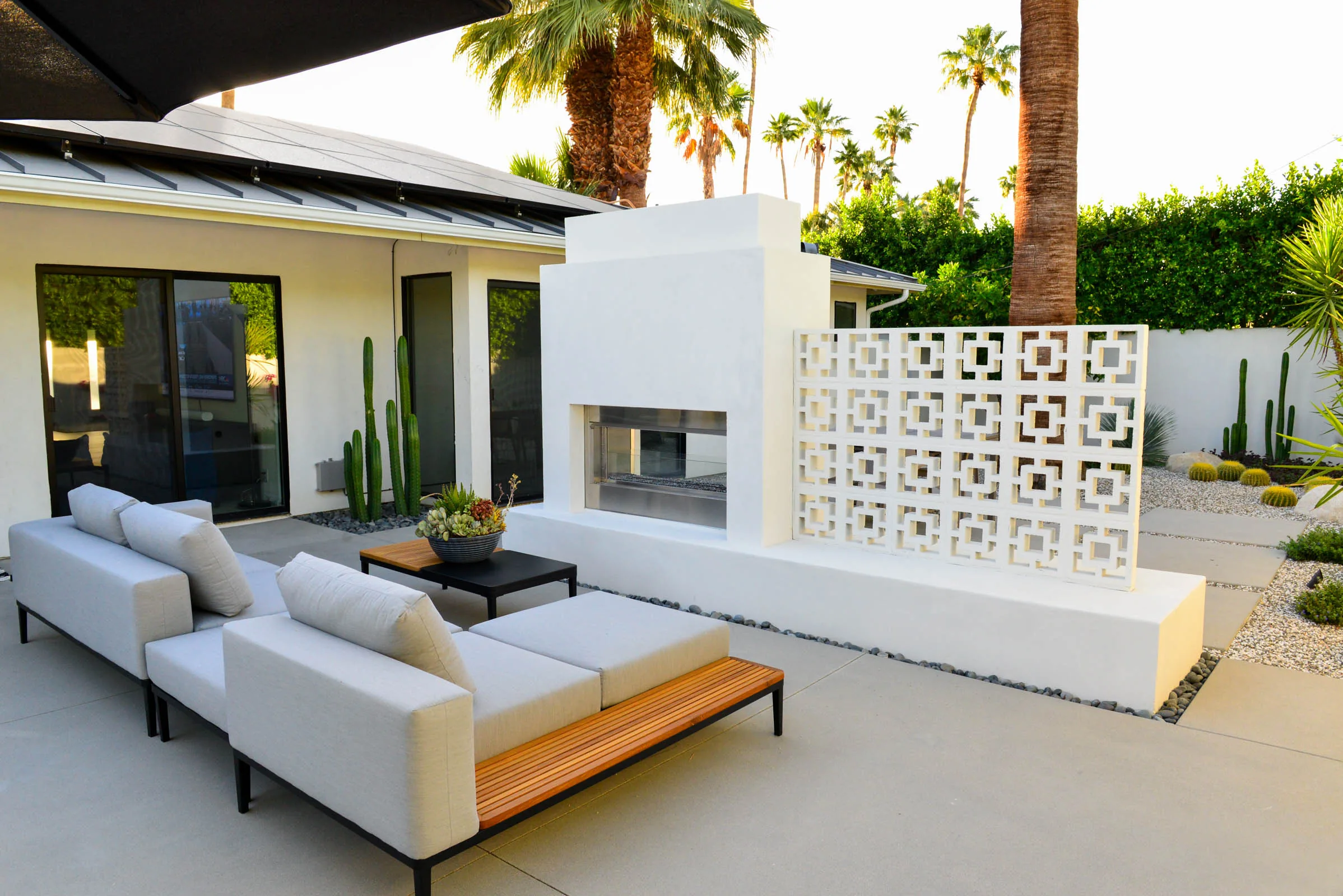 Breeze block fireplace wall and lounge seating on a concrete patio at the Manzanita residence